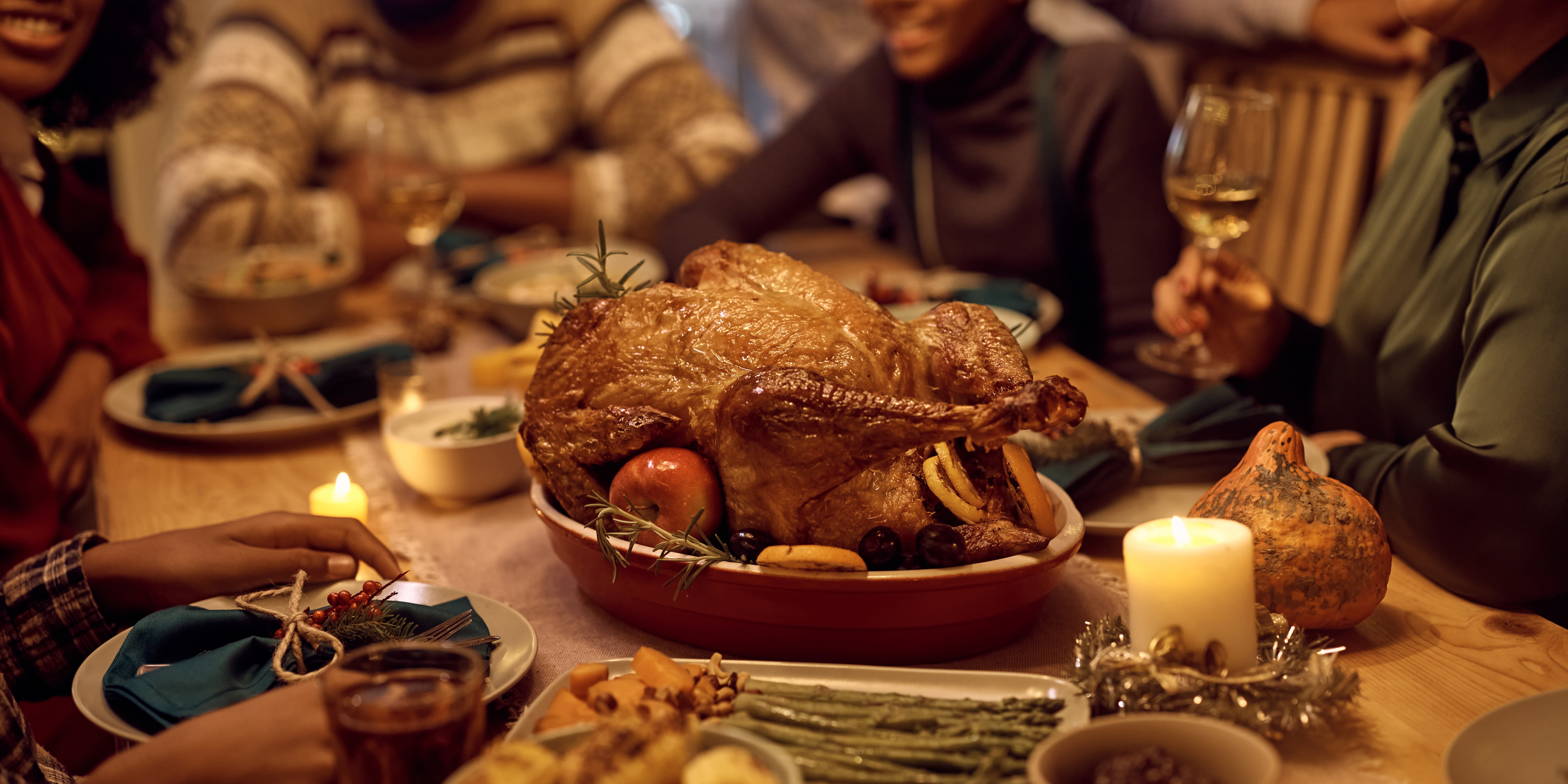 Family gathered around a Thanksgiving dinner table with turkey, candles, and warm lighting, symbolizing gratitude, healing, and new traditions after divorce.